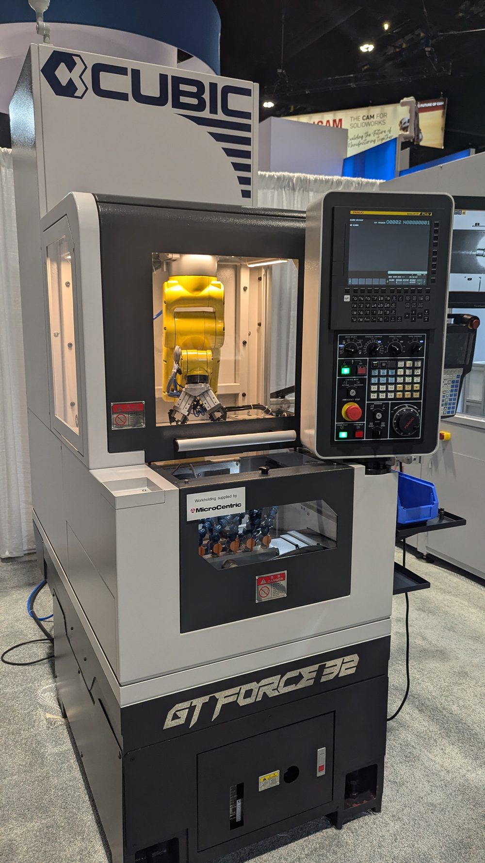 Cubic GT Force-32 gang-tool CNC lathe with a yellow FANUC robot visible inside the guarded loader enclosure above the work zone, alongside the FANUC CNC control panel